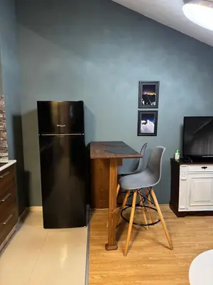 a kitchen with a refrigerator and a table and a chair at Belmont Apartment in Bansko