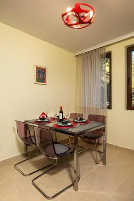 a dining room with a glass table and chairs at Апартамент Боров рай in Velingrad