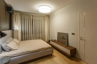 a bedroom with a bed and a large window at NDK - Grand View Apartment in Sofia