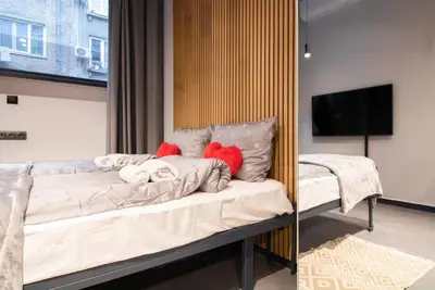 a bedroom with a bed with pillows and a television at Near NDK - Washer&Dryer - Fast Wi-Fi - Kitchenette in Sofia