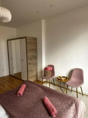 a bedroom with a bed and two chairs and a mirror at Serdika Central Stay - 2BD next to Serdika Metro Station in Sofia