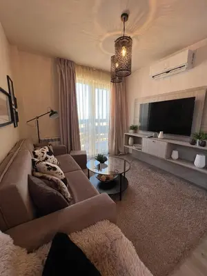 a living room with a couch and a flat screen tv at BANSKO Deluxe Apartment Belvedere - 350m SkiLift in Bansko