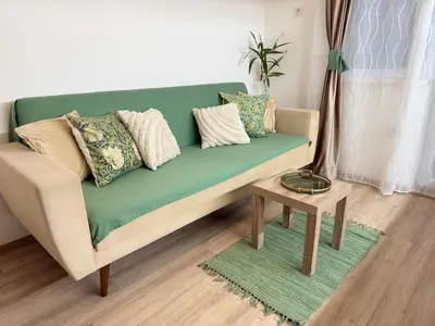 a green couch in a living room with a table at Center Chill ARTpartment in Sofia