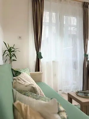 a bedroom with a bed and a window with curtains at Center Chill ARTpartment in Sofia