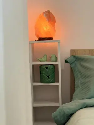 a shelf next to a bed with a bowl on top at Center Chill ARTpartment in Sofia