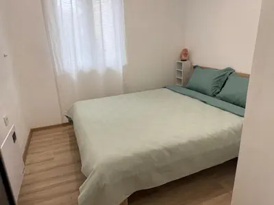 a bedroom with a bed with green sheets and a window at Center Chill ARTpartment in Sofia