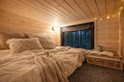 a bedroom with a large bed with a window at Малка Къщичка Бяла Черква