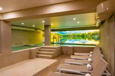 a room with a swimming pool and lounge chairs at Семеен хотел РАЙ in Ognyanovo