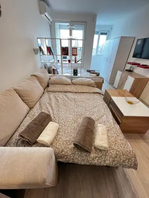 a large bed with pillows on it in a room at Warsaw Cozy Studio near UNSS and NSA with Balcony in Sofia