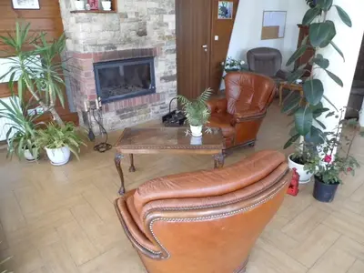 a living room with leather chairs and a fireplace at Apartment at the foot of Pirin in Bansko