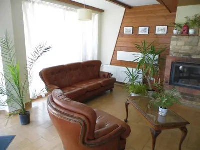 a living room with a leather couch and a fireplace at Apartment at the foot of Pirin in Bansko