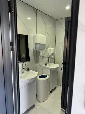 a white bathroom with two sinks and a mirror at Caravan for rent in Bansko