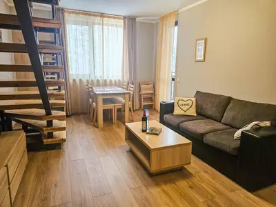 a living room with a couch and a table at Vista Apartment in Borovets