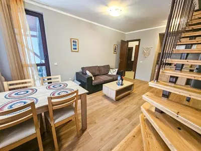 a living room with a table and a couch at Vista Apartment in Borovets