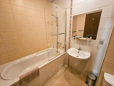 a bathroom with a bath tub and a sink at Vista Apartment in Borovets