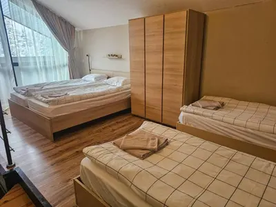 a bedroom with two beds and a large window at Vista Apartment in Borovets
