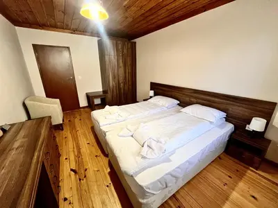 a bedroom with a large bed with white sheets at Къща за гости в село Проглед - комплекс Божидарица 4А in Progled