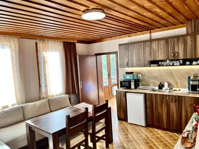 a living room with a table and a kitchen at Къща за гости в село Проглед - комплекс Божидарица 4А in Progled