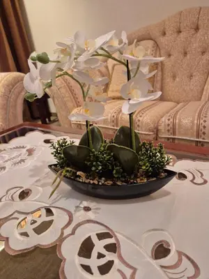 a table with a vase with white flowers on it at Mountain Heaven Downtown in Bansko