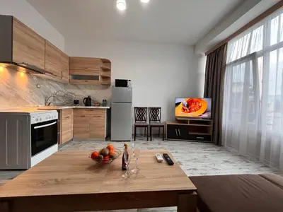 a kitchen with a table with a bowl of fruit on it at Апартамент Аксел in Panagyurishte