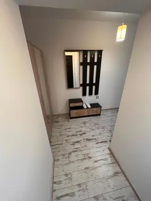 an empty hallway with a mirror and a table at Апартамент Аксел in Panagyurishte