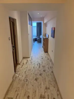 an empty hallway of an apartment with a hard wood floor at Апартамент Аксел in Panagyurishte