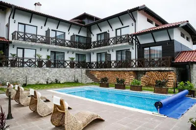 a house with a swimming pool and some chairs at Einstein House & Spa in Marchevo
