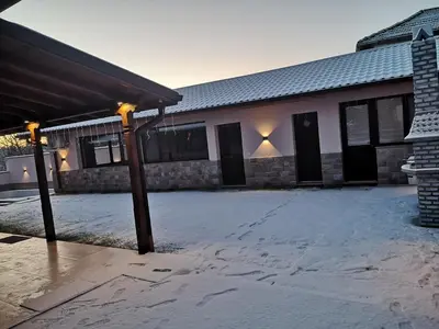a building with snow on the ground in front of it at Алтъна Калофер in Kalofer