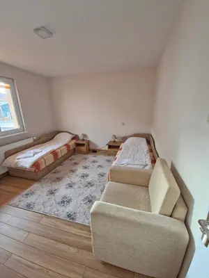 a living room with two beds and a couch at Guest house Belitsa in Semkovo