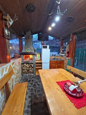a kitchen with a wooden table and a stove at Guest house Belitsa in Semkovo