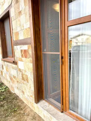 a glass door of a house with a window at The Mountain Hug 1BR by SI Stay in Bansko