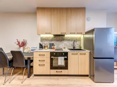 a kitchen with wooden cabinets and a stainless steel refrigerator at Alpine Glow Studio with Parking Pamporovo in Pamporovo