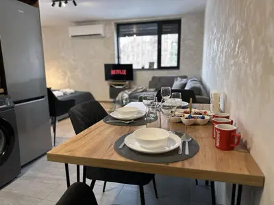 a dining room table with plates and wine glasses at New! Park Lane Bansko Residences in Bansko