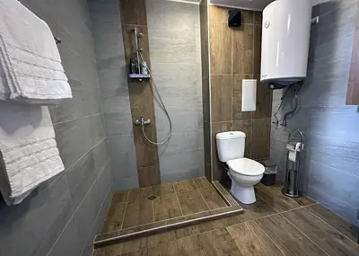 a bathroom with a shower and a toilet in it at New! Park Lane Bansko Residences in Bansko