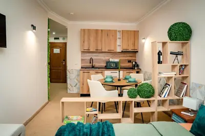 a kitchen and living room with a table and chairs at Bansko Peak Apartments 102 in Bansko