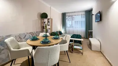 a living room with a table and chairs at Bansko Peak Apartments 102 in Bansko