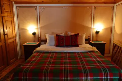 a bedroom with a bed with a red and green blanket at Guest House Zlatniyat Telets in Koprivshtitsa