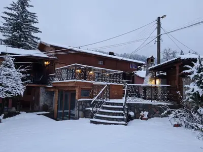 a house with a staircase in the snow at Guest House Zlatniyat Telets in Koprivshtitsa