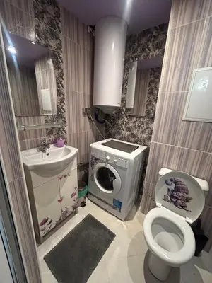 a bathroom with a toilet a sink and a washing machine at Cozy apartment kids friendly in Sofia