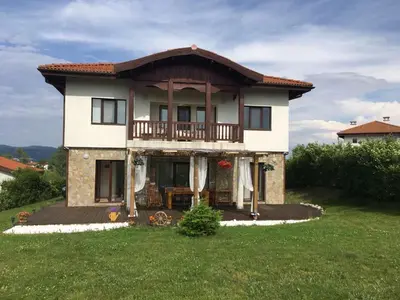 a house with a balcony on top of a yard at Villa Dreams in Golf Club Ibar in Dolna Banya