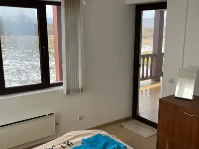 a room with a bed and windows with a view at Villa Dreams in Golf Club Ibar in Dolna Banya