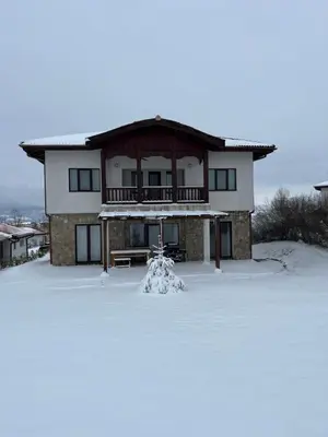 a house with snow in front of it at Villa Dreams in Golf Club Ibar in Dolna Banya