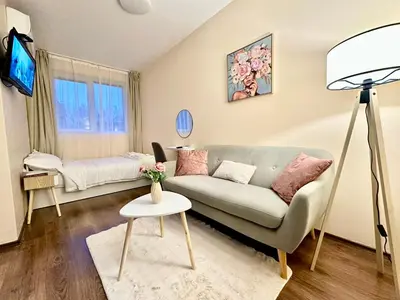 a living room with a couch and a tv at Ikigai Living - Cozy Studio in Studentski Grad in Sofia
