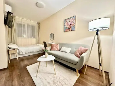 a living room with a couch and a table at Ikigai Living - Cozy Studio in Studentski Grad in Sofia