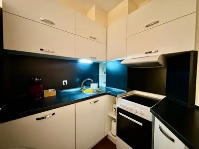 a small kitchen with white cabinets and a sink at Ikigai Living - Cozy Studio in Studentski Grad in Sofia