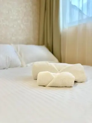 two towels sitting on top of a white bed at Ikigai Living - Cozy Studio in Studentski Grad in Sofia