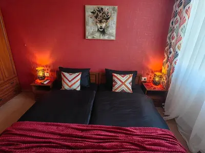 a bedroom with a bed and two tables with lamps at Bansko Peak Apartments 116 in Bansko