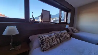 a bedroom with a bed and a window with a cat at 3 bedroom Penthouse only 700 meters from Ski Lift in Bansko