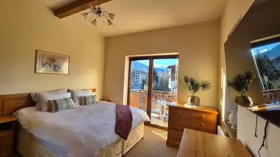 a bedroom with a large bed and a balcony at 3 bedroom Penthouse only 700 meters from Ski Lift in Bansko