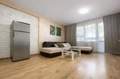 a living room with a bed and a refrigerator at Prime Apartment Seven & Parking in Plovdiv